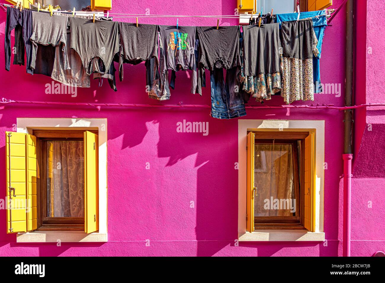 Lavaggio appeso ad asciugare da case colorate sull'isola italiana di Burano An Island nella laguna veneta, Venezia, Italia Foto Stock