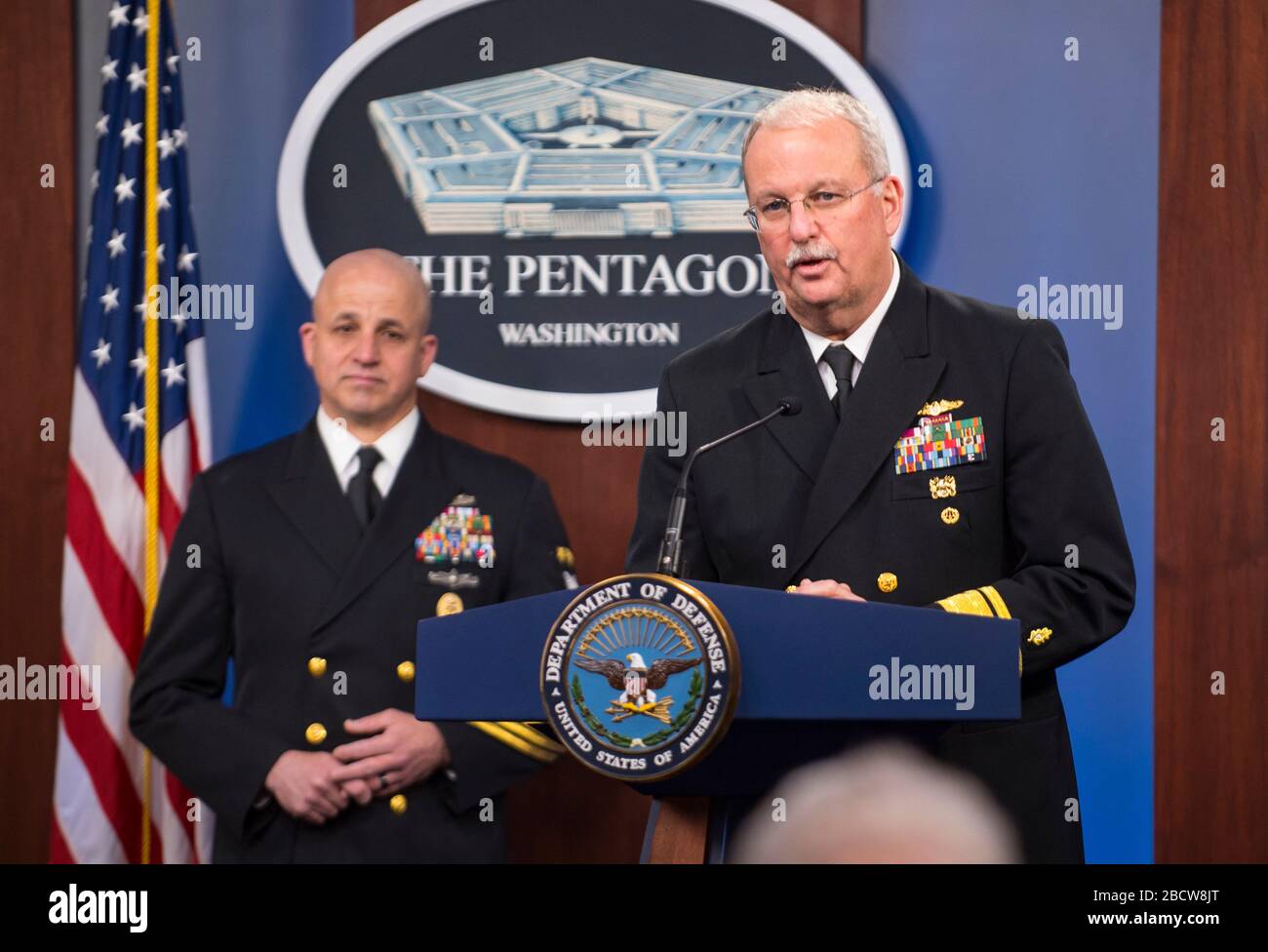 Il direttore generale degli Stati Uniti Petty Officer della Marina Russell Smith guarda come l'ammiraglio posteriore Bruce Gillingham, destra, chirurgo generale della Marina, briefing reporter sulla pandemia COVID-19 al Pentagono 25 marzo 2020 ad Arlington, Virginia. Foto Stock
