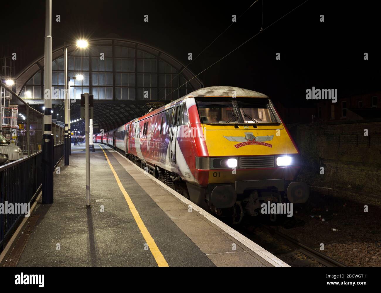 LNER classe 91 locomotiva elettrica 91101 Flying Scotsman alla stazione ferroviaria di Darlington sulla linea principale della costa orientale di notte. Foto Stock