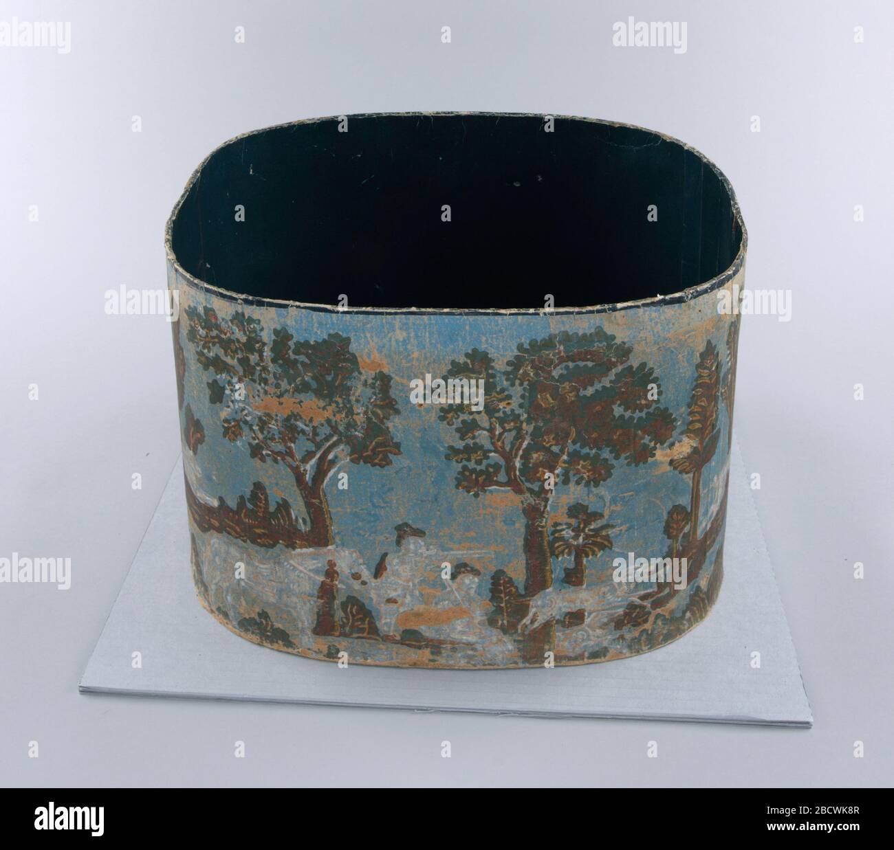 Bandbox. Ricerca in ProgressCacciatori con cannoni, uno dei quali è seduto e l'altro nell'atto di tiro, in piedi. Cavallo in piedi, a sinistra. A destra, cani in inseguimento. Sfondo di alberi scuri e terreno spiovente. Solo fondo scatola, senza coperchio. Bandbox Foto Stock