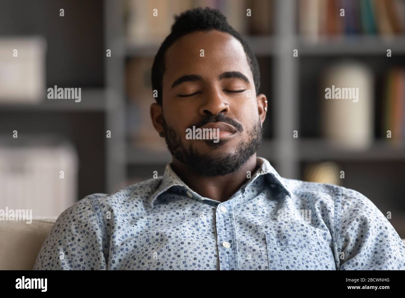 Uomo biraciale esausto addormentarsi in soggiorno Foto Stock