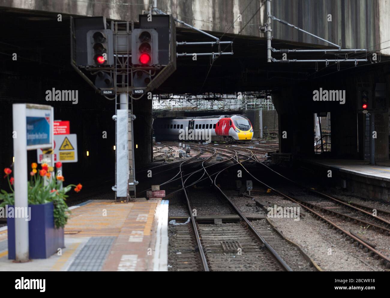 Virgin Trains West Coast Class 390 Alstom pendolino Train 390046 partenza da Birmingham New Street con segnali ferroviari rossi in primo piano Foto Stock