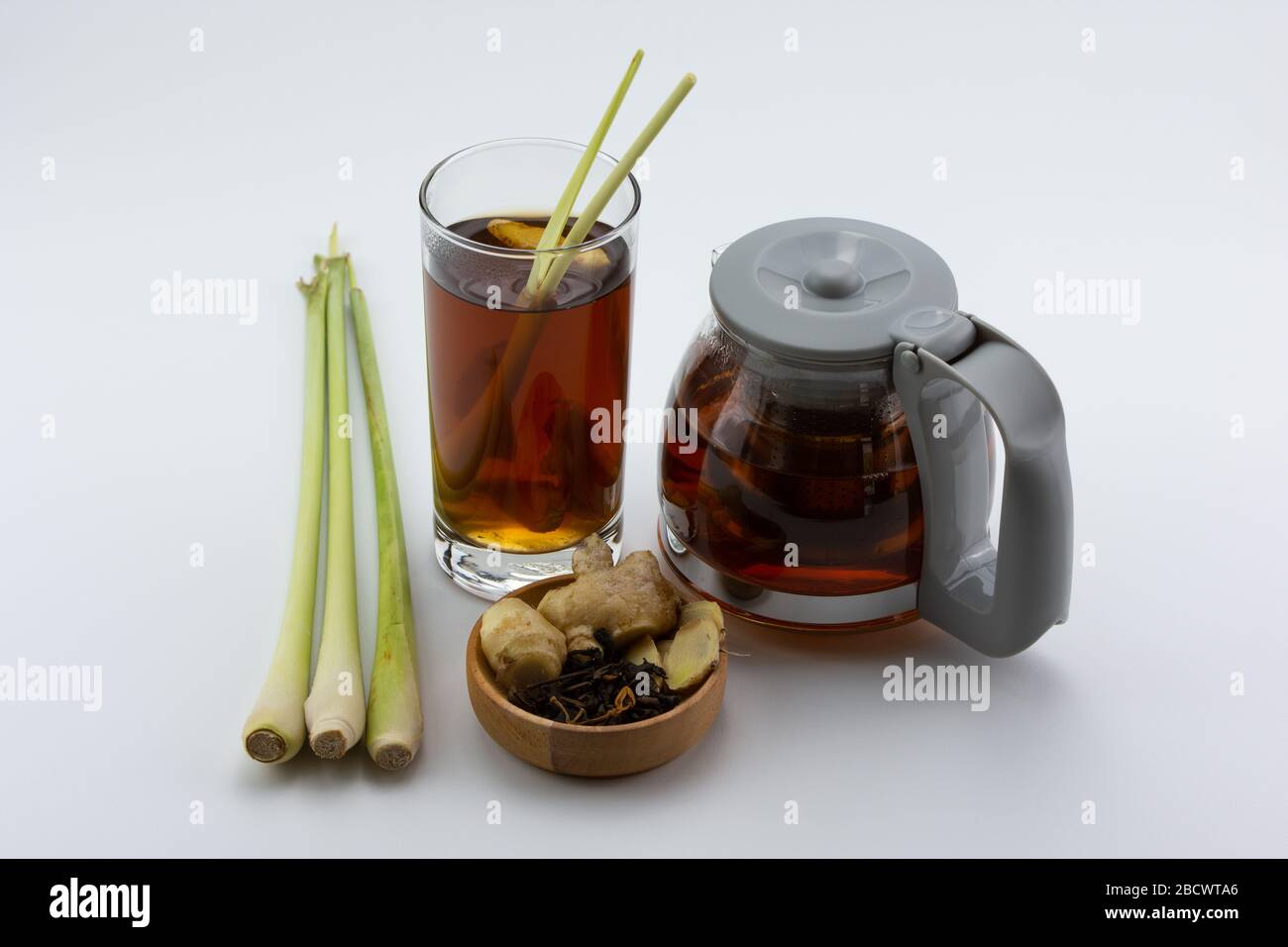 Ricetta tradizionale per bevande salutari su teiera e bicchiere con tè, zenzero, miele e limongrass su sfondo bianco. Foto Stock