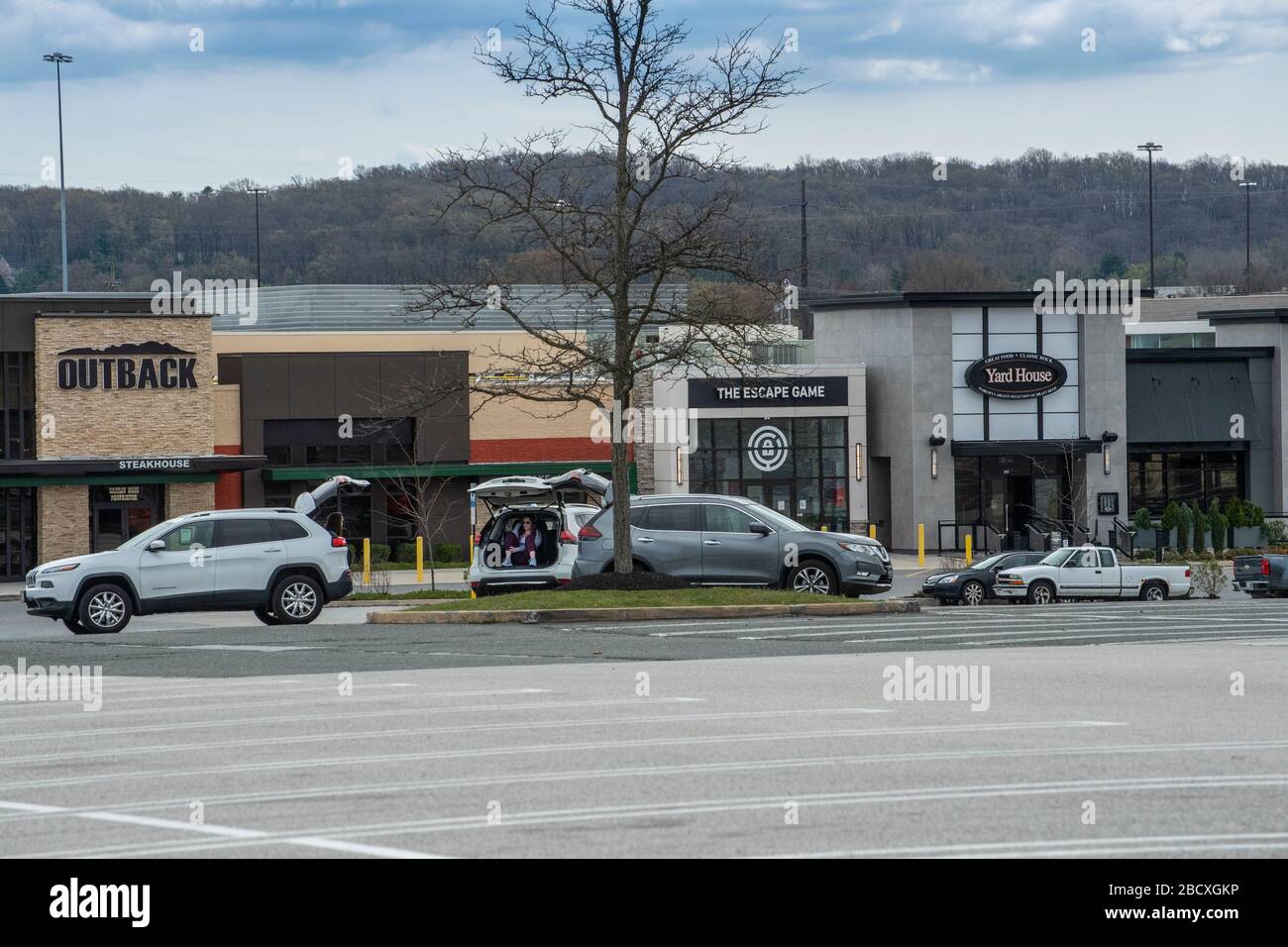 Persone che praticano la distanza sociale sicura a causa di Coronavirus Covid-19 nel parcheggio di parcheggio chiuso King of Prussia Mall, Pennsylvania, Stati Uniti Foto Stock