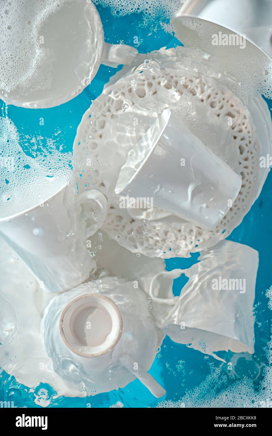 Concetto di piatti, piastre e tazze in porcellana imbevute di ondulazione d'acqua Foto Stock