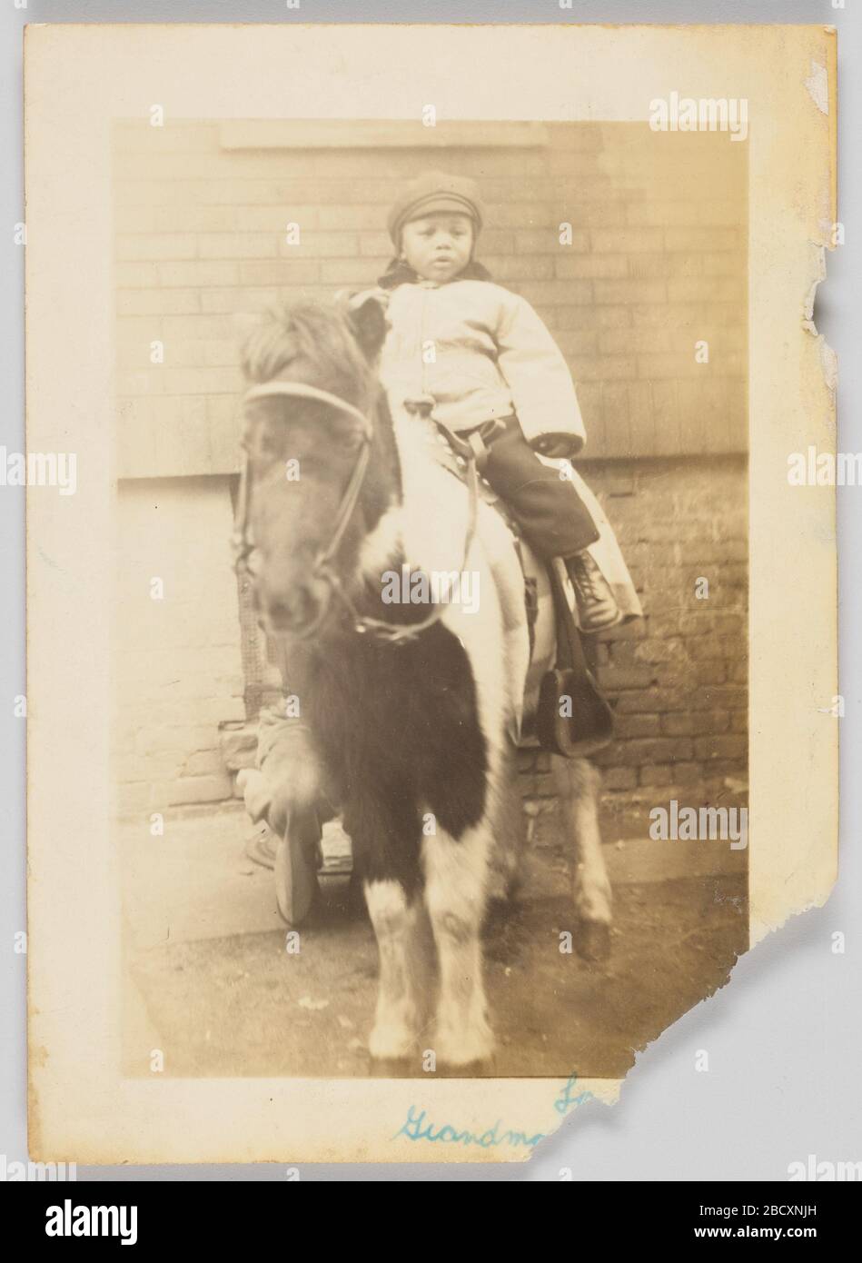Stampa fotografica di Paul Kendrick Bryant. Una fotografia in bianco e nero di Paul Kendrick Bryant seduto sopra un cavallo. Bryant indossa un cappello e un cappotto. L'angolo in basso a destra presenta un'iscrizione parziale in inchiostro blu, ma una sezione dell'angolo è stata strappata. Stampa fotografica di Paul Kendrick Bryant Foto Stock