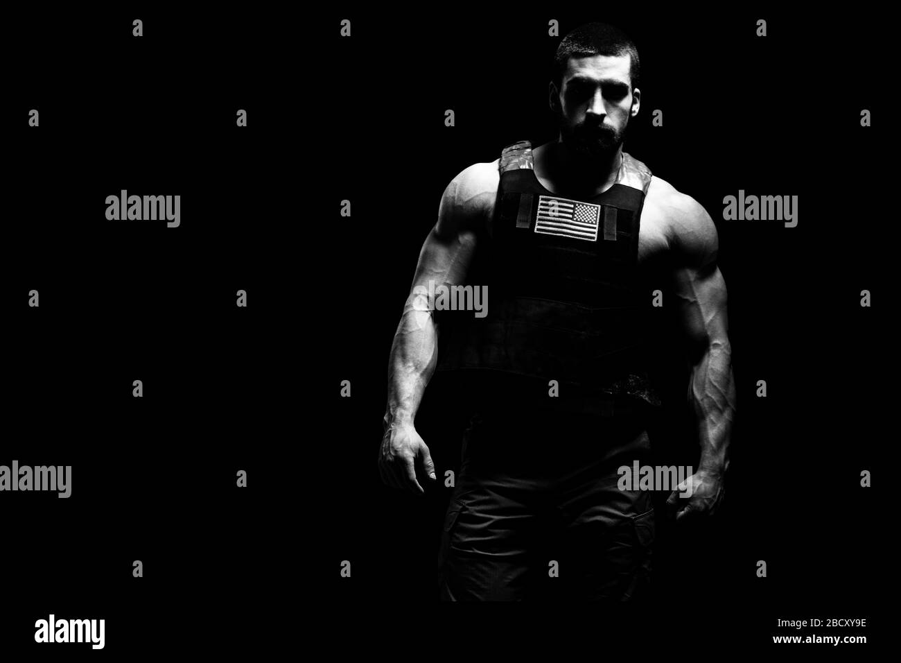 Bodybuilder Ritratto di Soldato con Bulletproof Vest e noi bandiera su uno sfondo nero Foto Stock