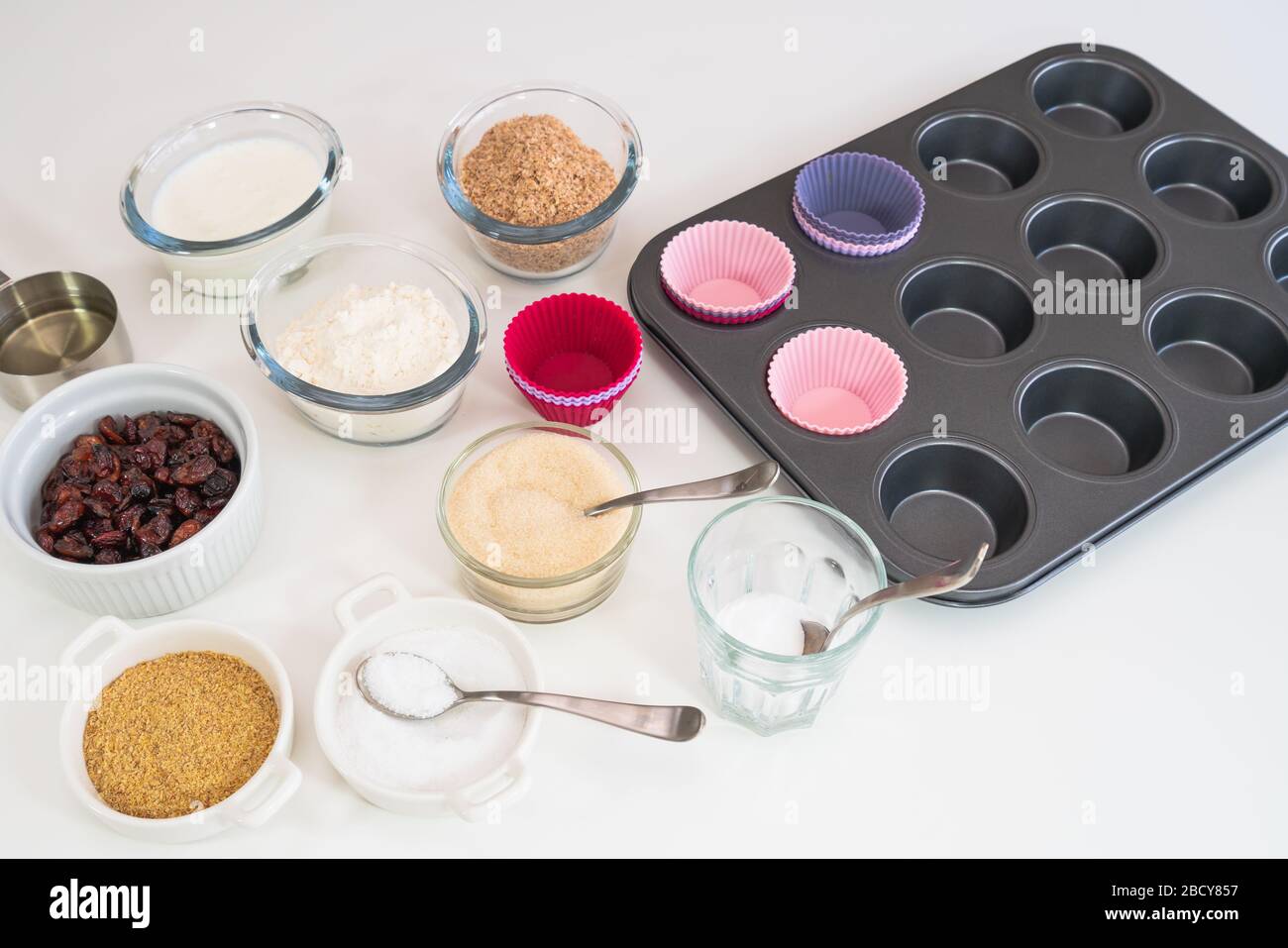 Muffin Bran con ricetta di mirtilli rossi secchi. Bran, farina, latticello, bacche secche e alcuni altri ingredienti si chiudono su un tavolo da cucina Foto Stock