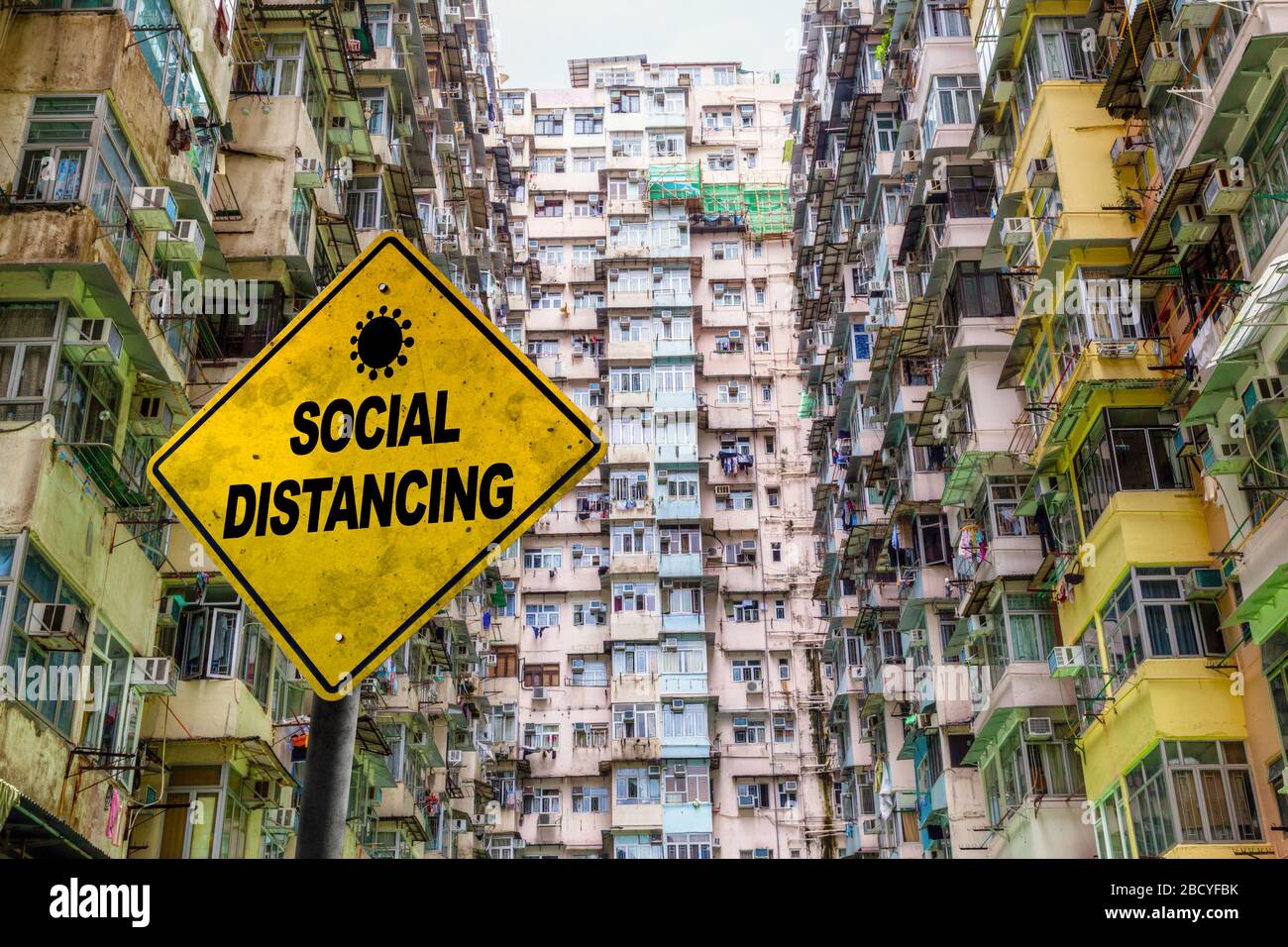 Segnale di avvertimento di distanza sociale di fronte a un affollato pubblico immobiliare a Quarry Bay, Hong Kong. Concetto di importanza della distanza fisica a p Foto Stock