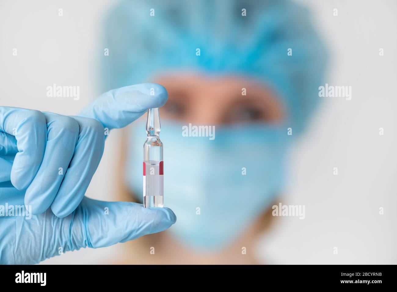 Fiala per iniezione in mano dell'infermiere. Flaconcino di vetro per uso medico per la vaccinazione. Attrezzatura scientifica, farmaco liquido o vaccino. Concetto di medicina Foto Stock