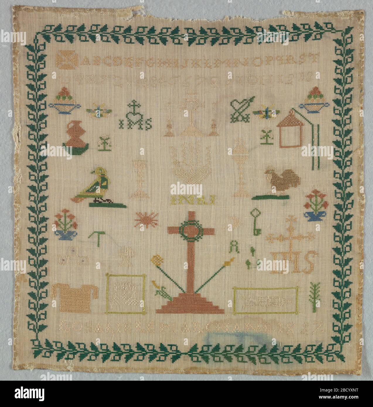 Campionatore. Ricerca in ProgressAlphabet introdotta dalla croce maltese seguita da motivi isolati, prevalentemente religiosi, contenuti all'interno di un campionatore di confine floreale Foto Stock