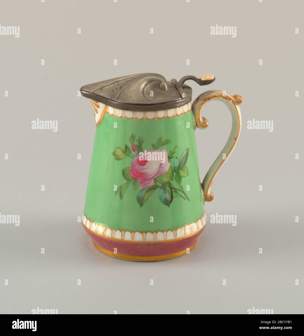 Tankard con coperchio in peltro. Ricerca in ProgressJug con lati diritti, restringimento in alto e tondo in basso. Aprire il beccuccio e la maniglia. Modanatura di scarico in alto e in basso. Macinato verde mela con pittura policroma di rosa e panties. Copricapo incernierato a conchiglia. Tankard con coperchio in peltro Foto Stock