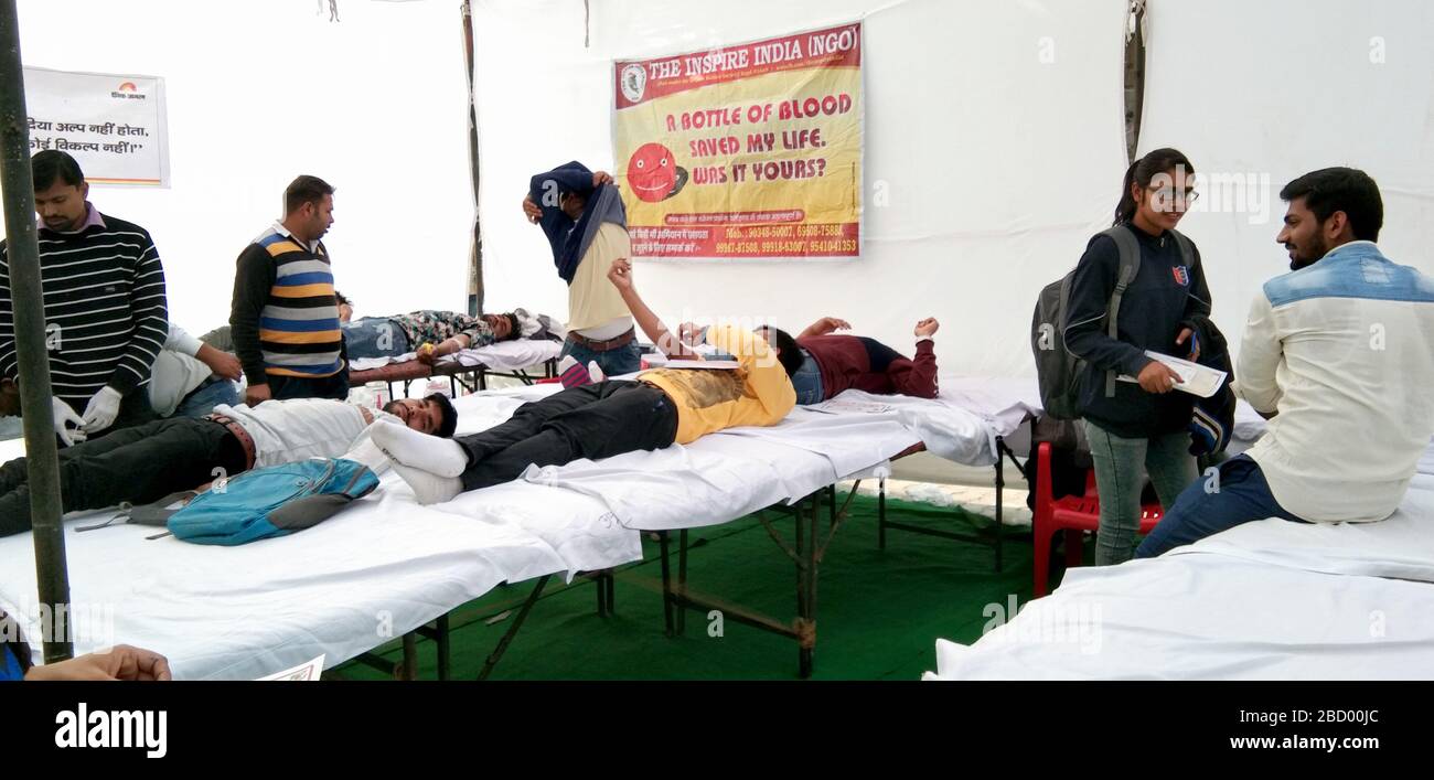 Dicembre 2019, Hisar, Haryana, India : campo di donazione di sangue organizzato da 'l'ONG Inspire India' in un villaggio all'aperto, donatori di sangue felice sui letti. Foto Stock