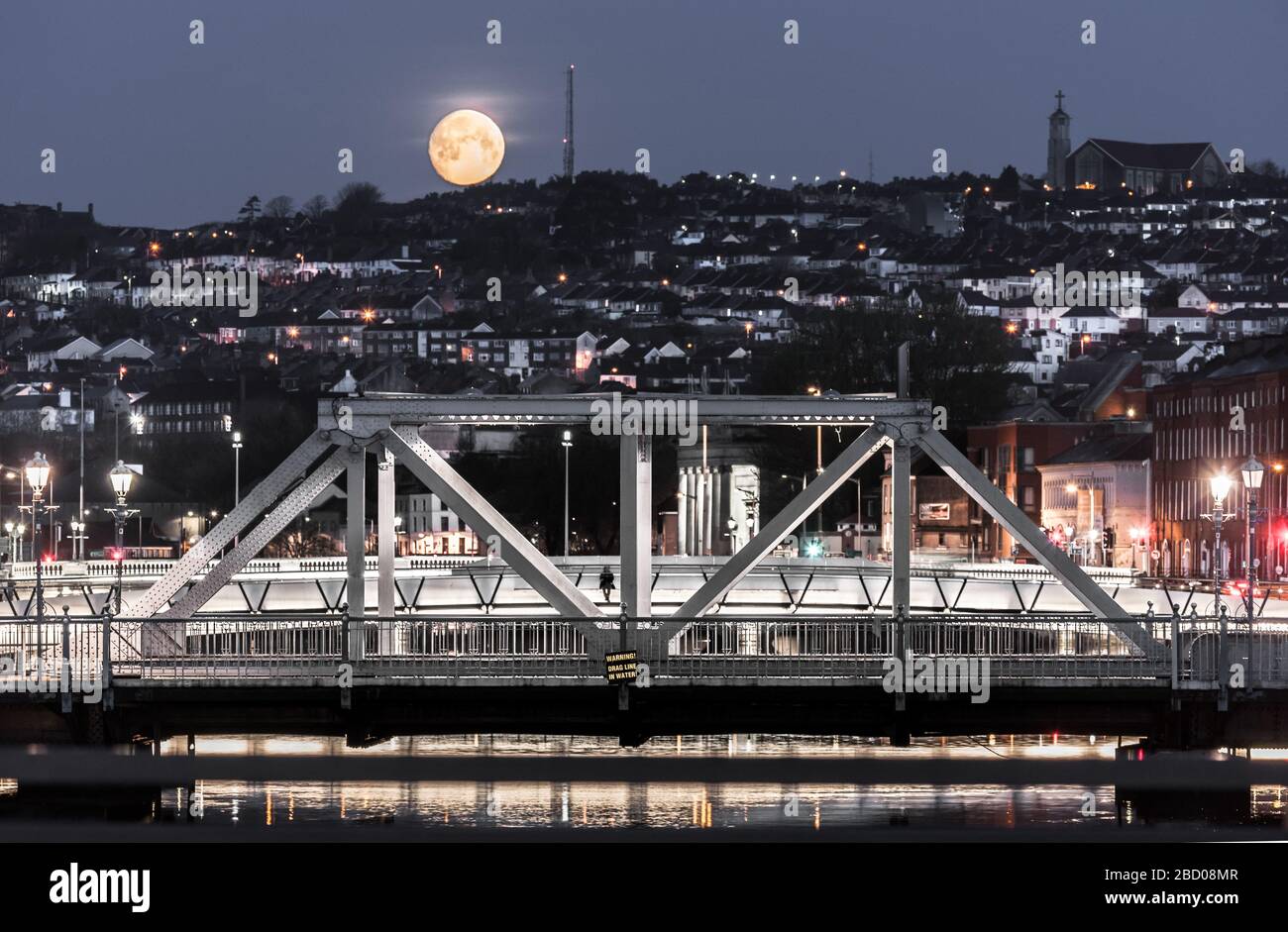 Cork City, Cork, Irlanda. 06 aprile 2020. Una vista del Ponte Brian Boru e del lato nord della città mentre una luna ardente gibbous desends nella città di Cork, Irlanda. - credito; David Creedon / Alamy Live News Foto Stock