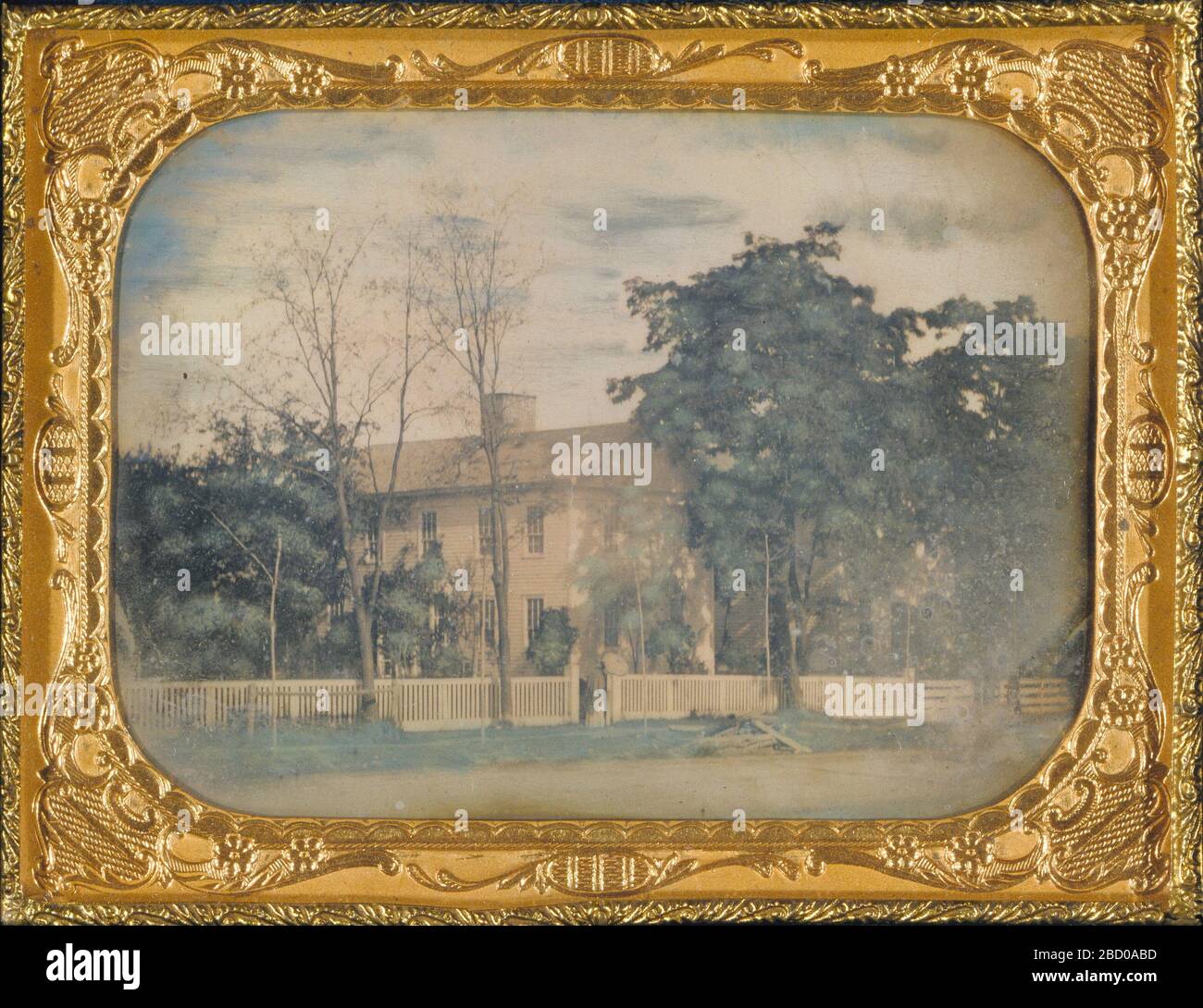 Casa con fence bianca e gli alberi. Foto Stock
