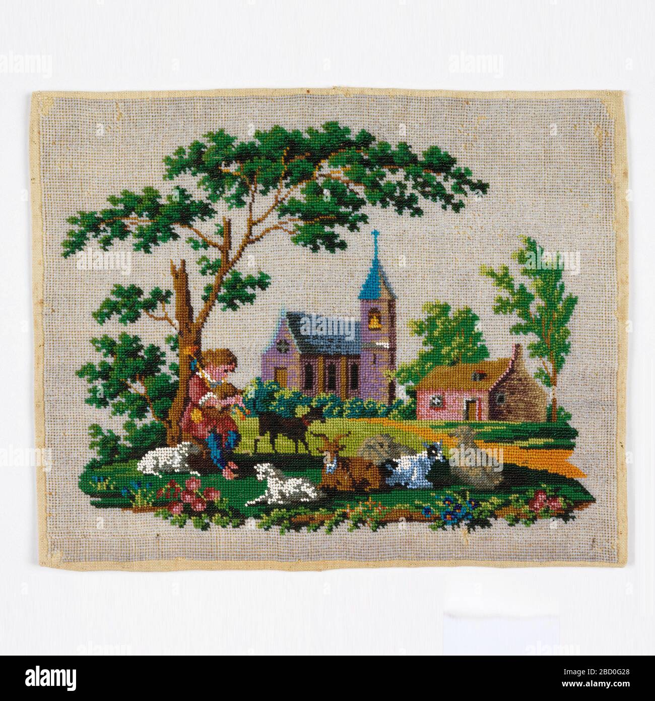 Immagine con bordatura. Ricerca in ProgressPanel di lino ricamato con perle di vetro colorate per creare una scena paesaggistica con una chiesa e una casa, e un ragazzo che gioca tubi sotto un grande albero circondato da pecore e capre. Immagine con bordatura Foto Stock
