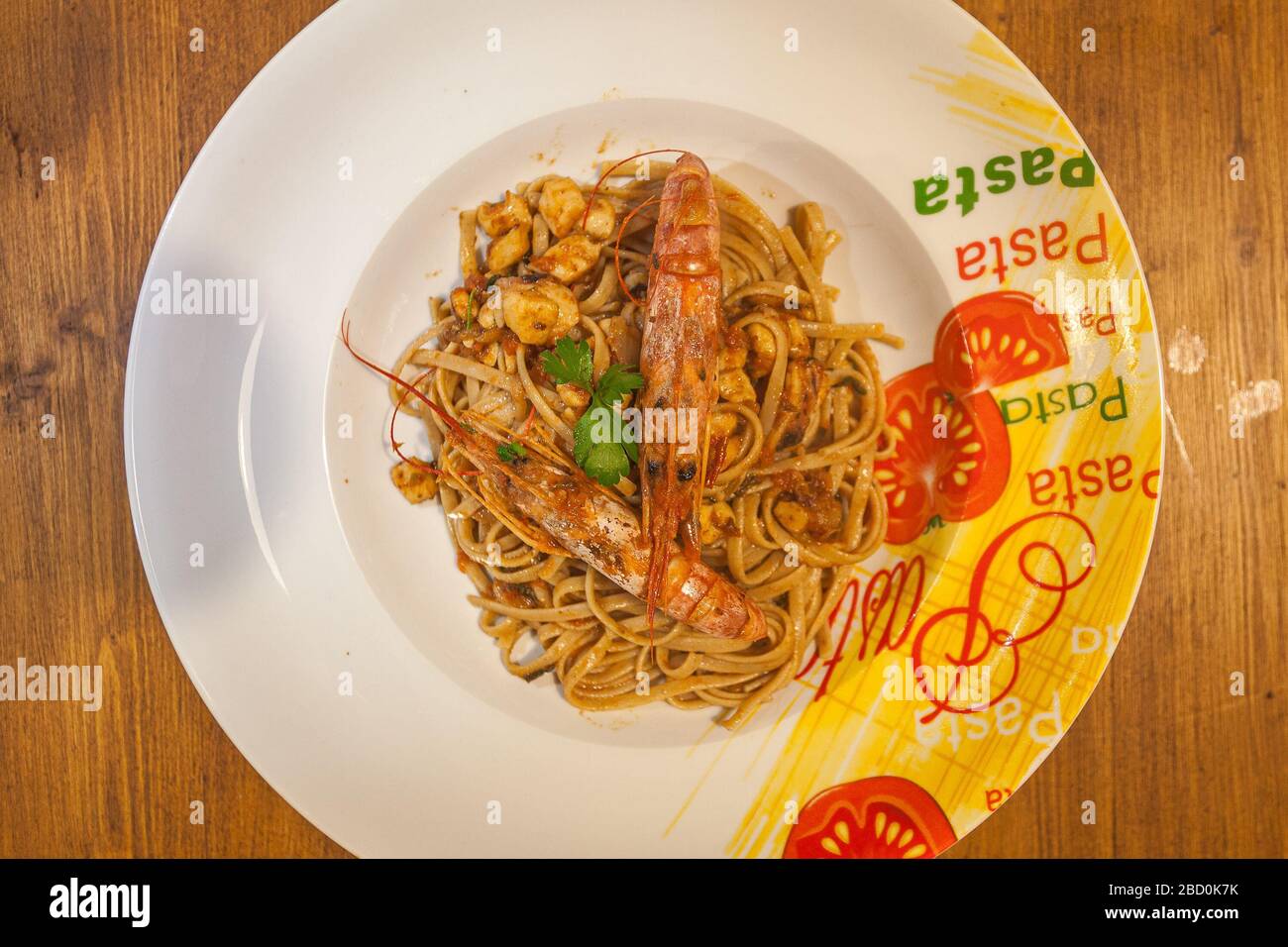 Piatto di linguine con gamberi su sfondo ligneo Foto Stock