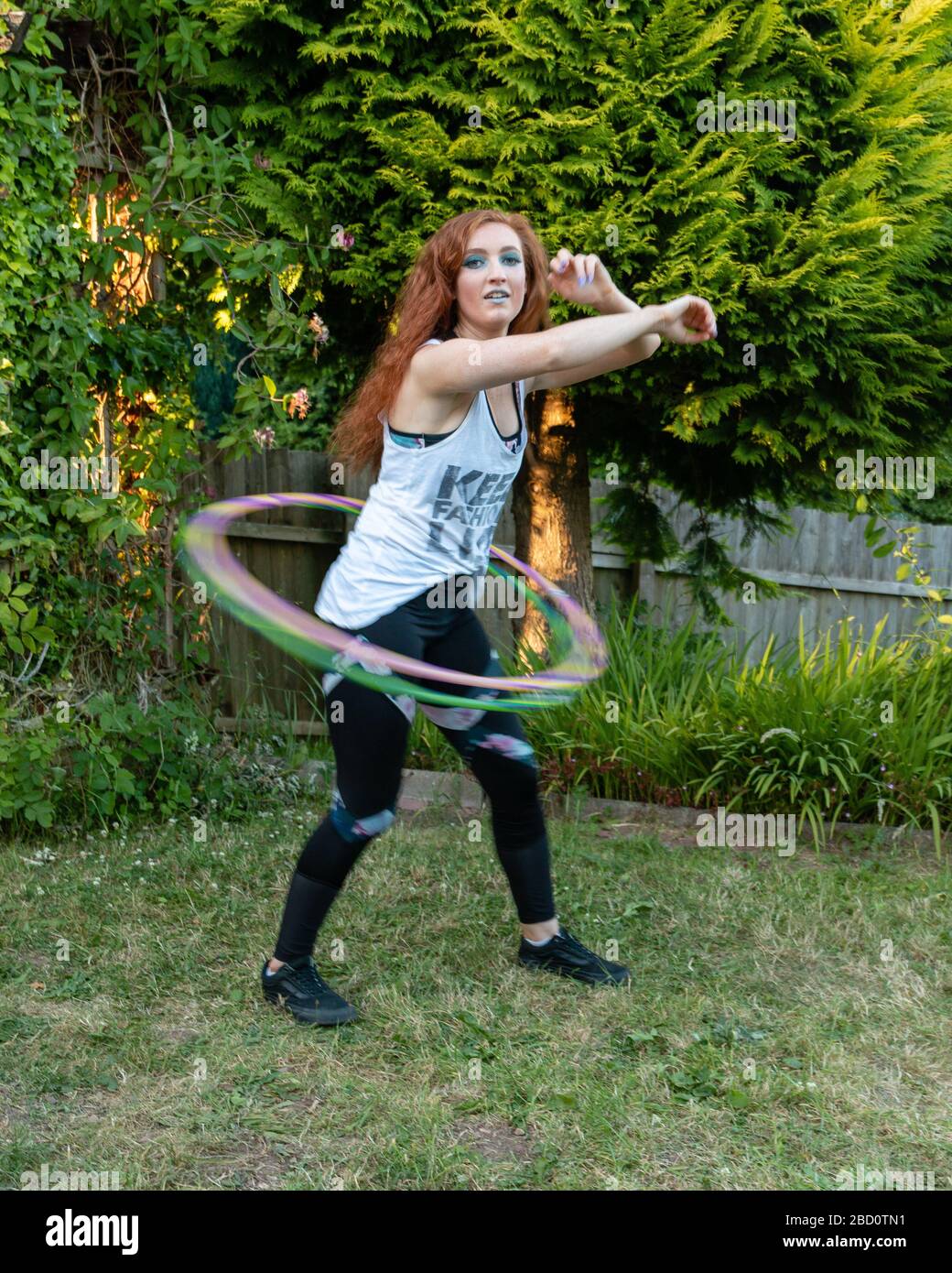 Giovane istruttrice attiva continua a giocare a hula hoops, Caerphilly, Galles del Sud, Regno Unito Foto Stock