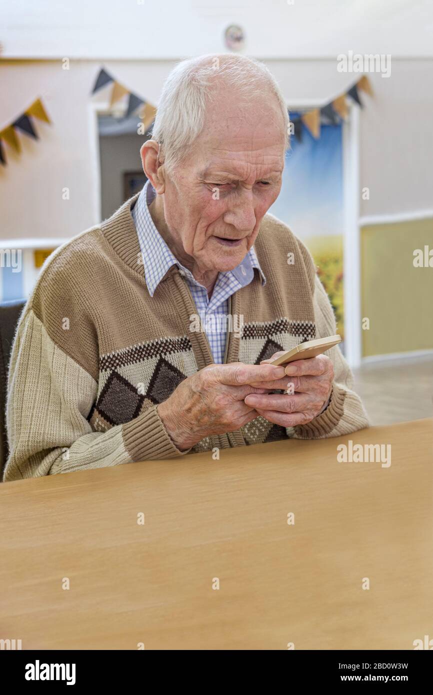 uomo di 97 anni in videochiamata con smartphone Foto Stock