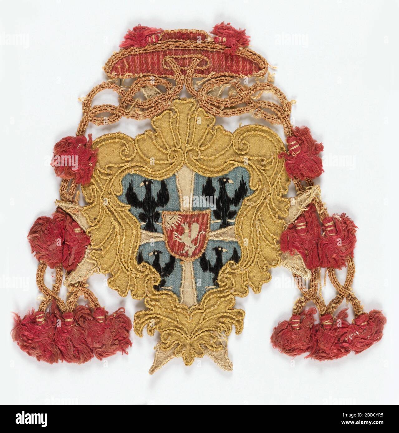 Badge. Ricerca in ProgressRed rasin cappello cardinal con cornice in raso giallo per scudo in raso blu tra nappine di cappello. Scudo diviso da croce maltese in raso bianco in quattro parti ciascuna con un'aquila nera ricamata in seta. Badge Foto Stock