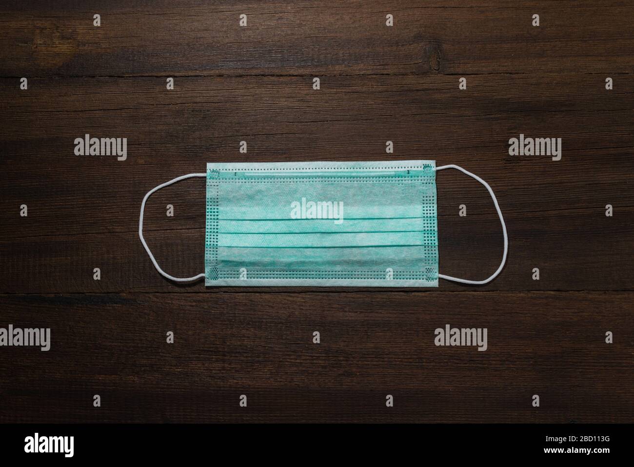 Maschera chirurgica con cinghie in gomma per le orecchie. Tipica maschera chirurgica a 3 strati per coprire bocca e naso. Maschera di procedura da batteri. Concetto di protezione. Foto Stock