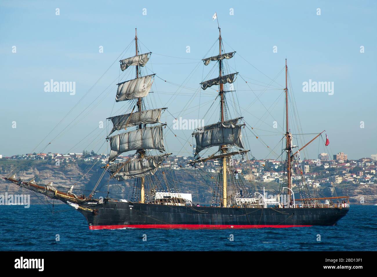 Sydney Australia, Schooner al largo della costa di Sydney con suburbia sullo sfondo Foto Stock