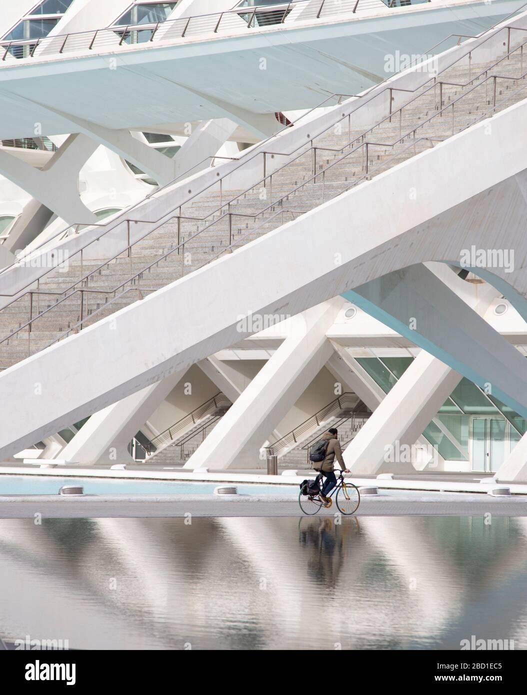 Un ciclista che corre di fronte al Museo della Scienza del Principe Felipe nella Città delle Arti e delle Scienze di Valencia, Spagna Foto Stock