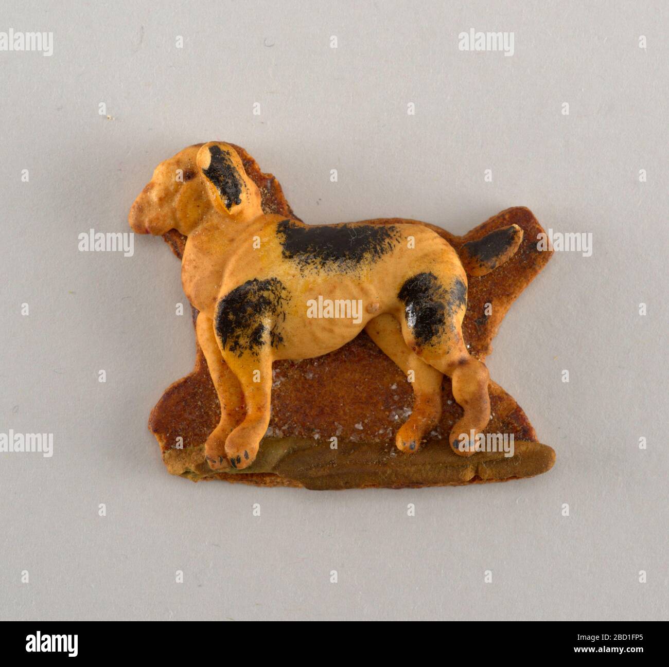 Ornamento di Natale. Ricerca in ProgressDog-come animale con macchie nere, in rilievo su terreno marrone con striscia di verde. Ornamento di Natale Foto Stock