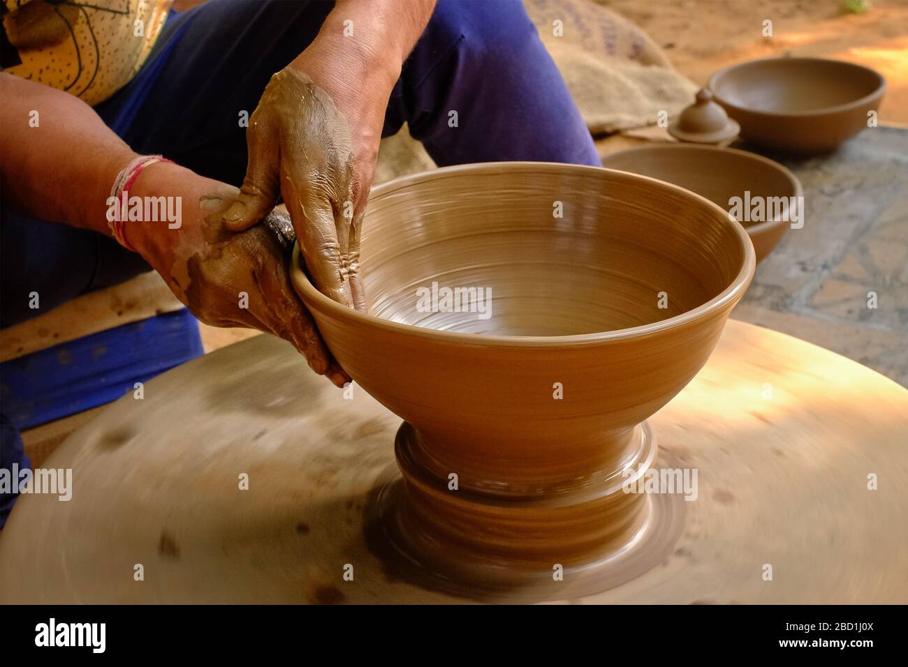 Ceramica - mani bagnate esperte di ceramica che modellano l'argilla sulla ruota di ceramica Foto Stock