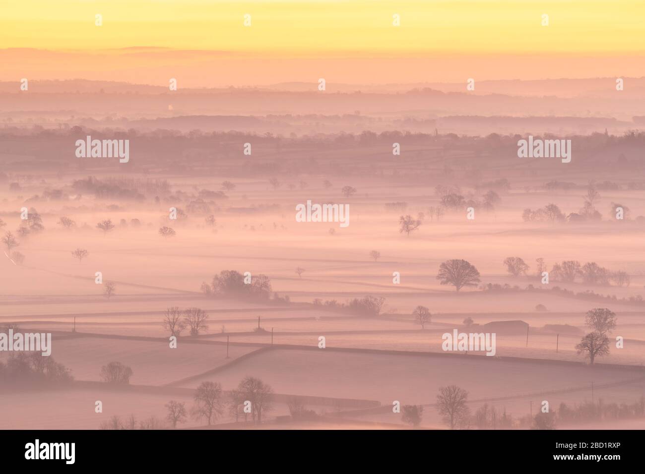 Dawn sopra la nebbia avvolta campagna dei livelli del Somerset in inverno, Glastonbury, Somerset, Inghilterra, Regno Unito, Europa Foto Stock