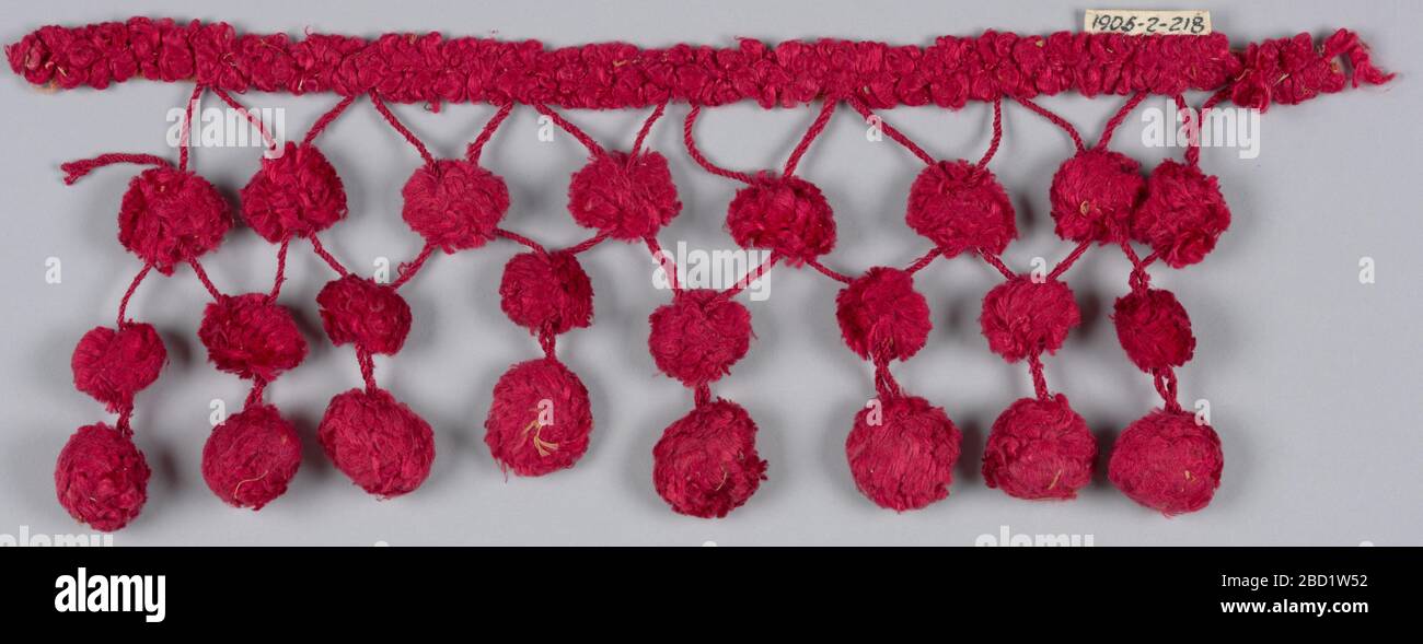 Frangia. Ricerca in ProgressRed fringe con una voce formata da anelli di seta rossa cuciti su un nastro stretto. Da questa voce pende cordicelle di seta rossa catturate insieme in un motivo di losanga e terminanti in anelli, ornati con sfere di filo interdentale. Frangia Foto Stock