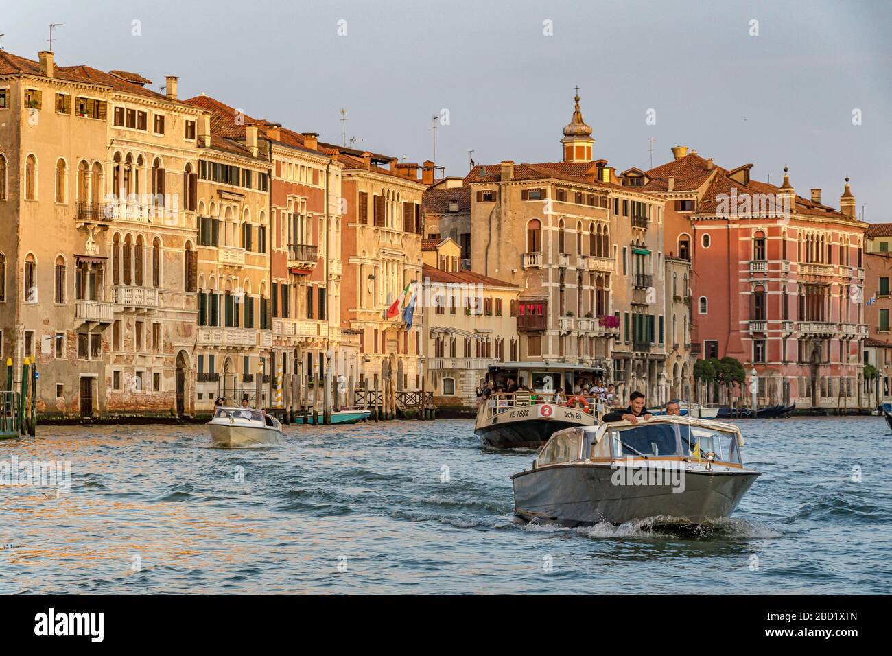 Un taxi d'acqua si snoda lungo il Canal Grande seguito da un percorso n. 2 Vaporetto, Venezia, Italia Foto Stock