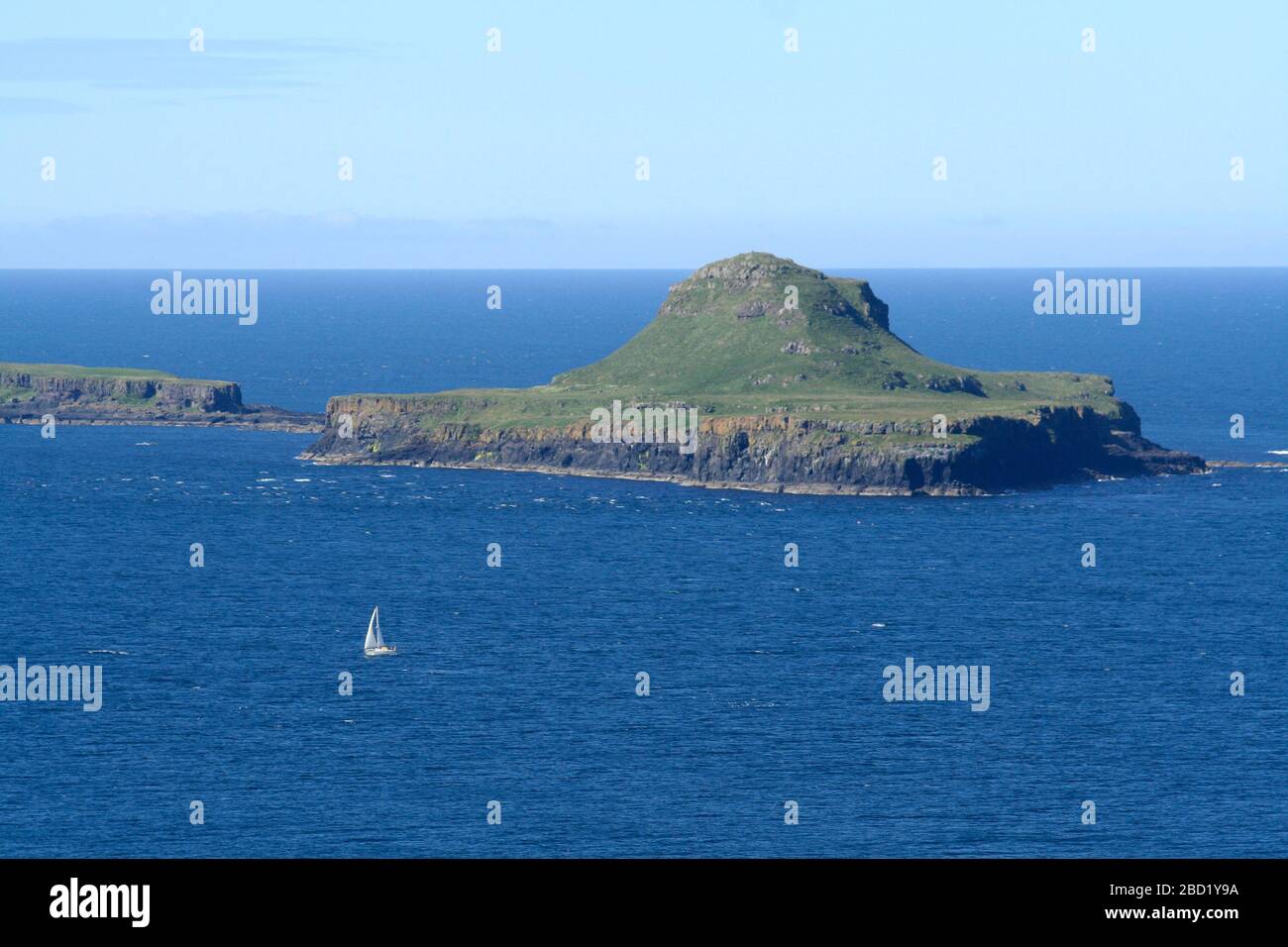 Yacht che naviga oltre Bac Mor, da lunga, Treshnish Isles, Ebrides, Scozia Foto Stock