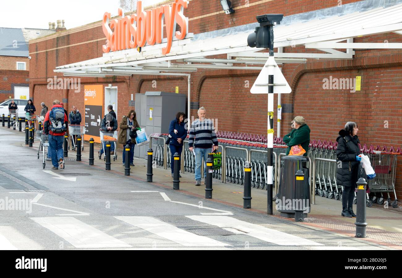 Coda distanziata al Supermarket, durante lo scoppio del virus Corona. Foto Stock