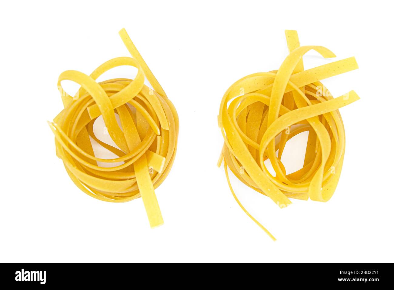 Fettuccine, pasta italiana arrotolata isolata su fondo bianco Foto Stock
