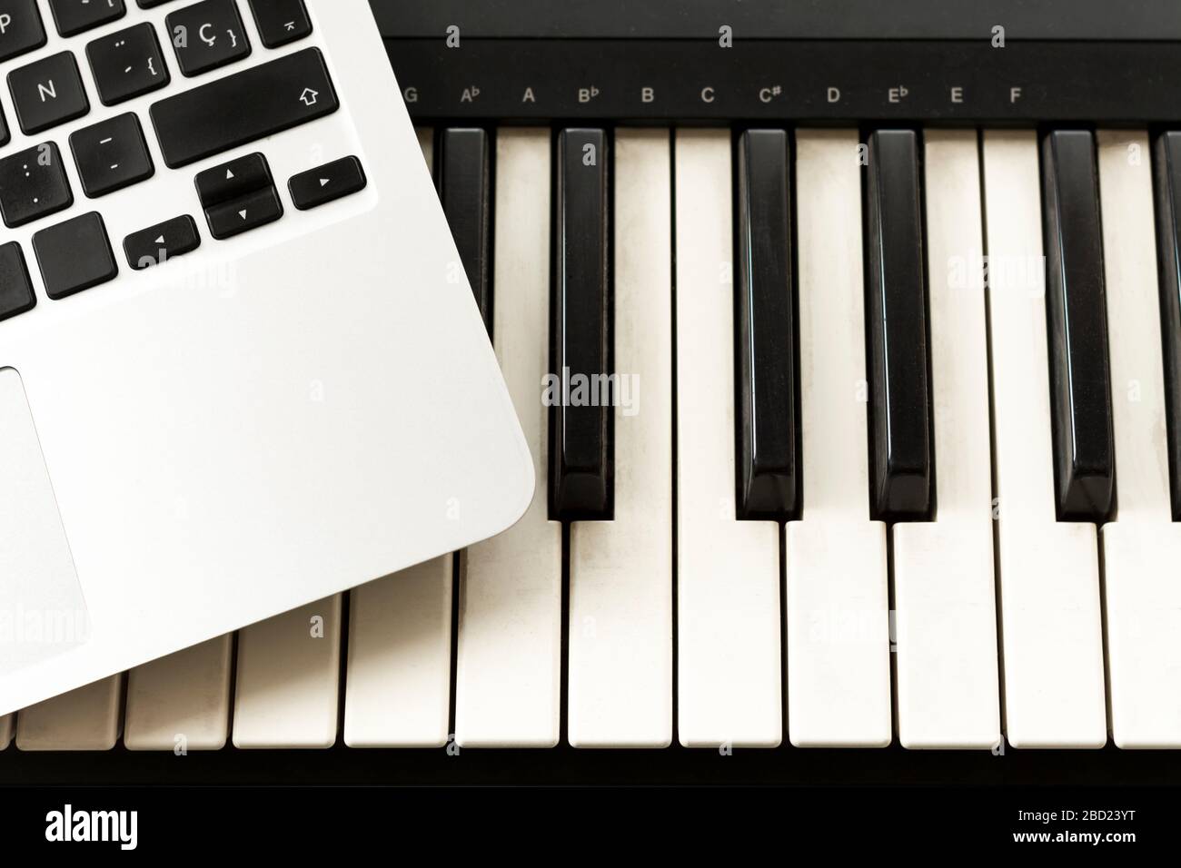 Tastiera e computer. Concetti di imparare a suonare musica online a casa, a lavorare da casa, autodidatta o autodidatta Foto Stock