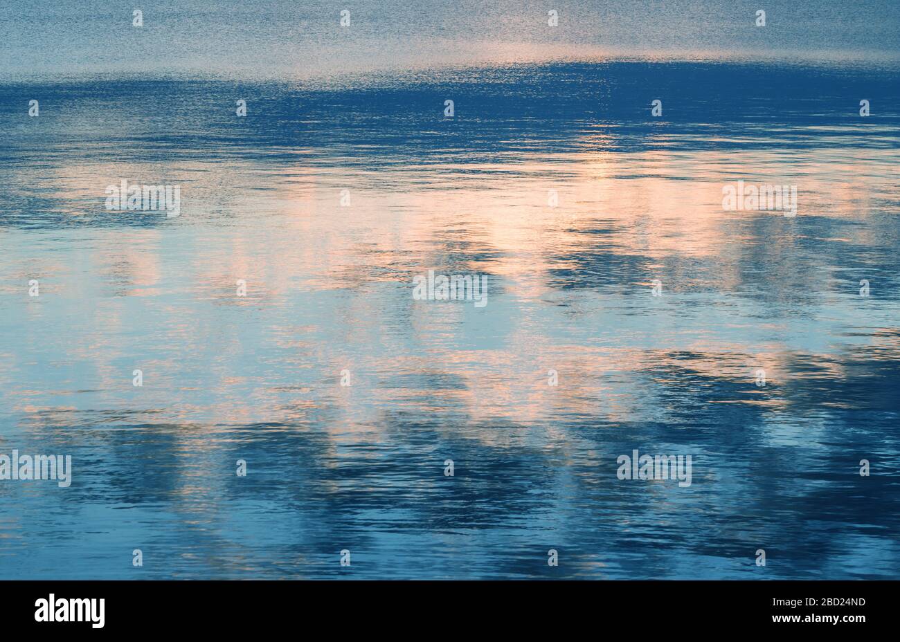 Riflessione del cielo e del sole nell'acqua di mare all'alba. Modello astratto Foto Stock