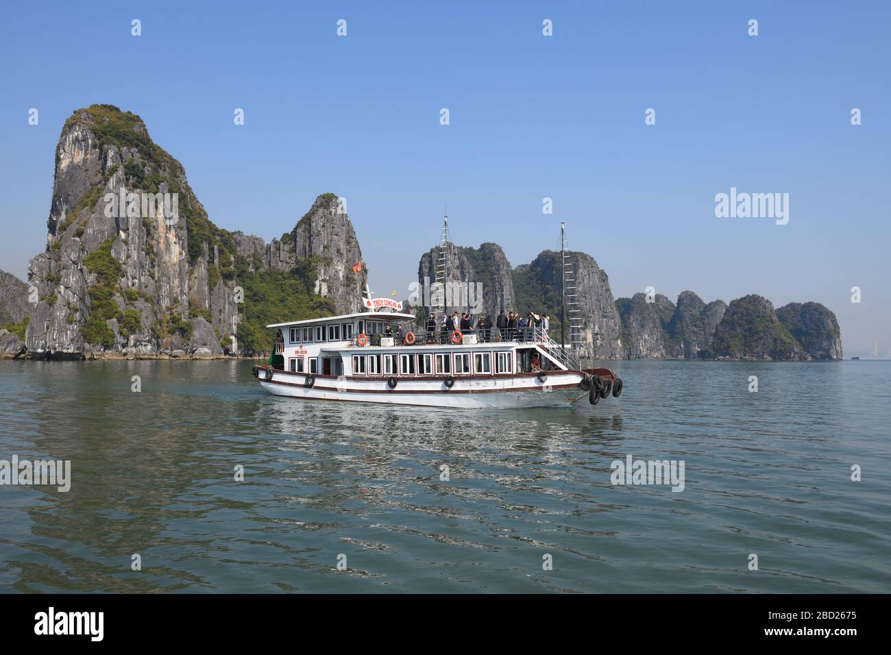 Una barca cinese spazzatura ferry turisti in una gita di un giorno attraverso le isole calcaree nel sito patrimonio mondiale dell'UNESCO di Halong Bay, Vietnam, Asia Foto Stock