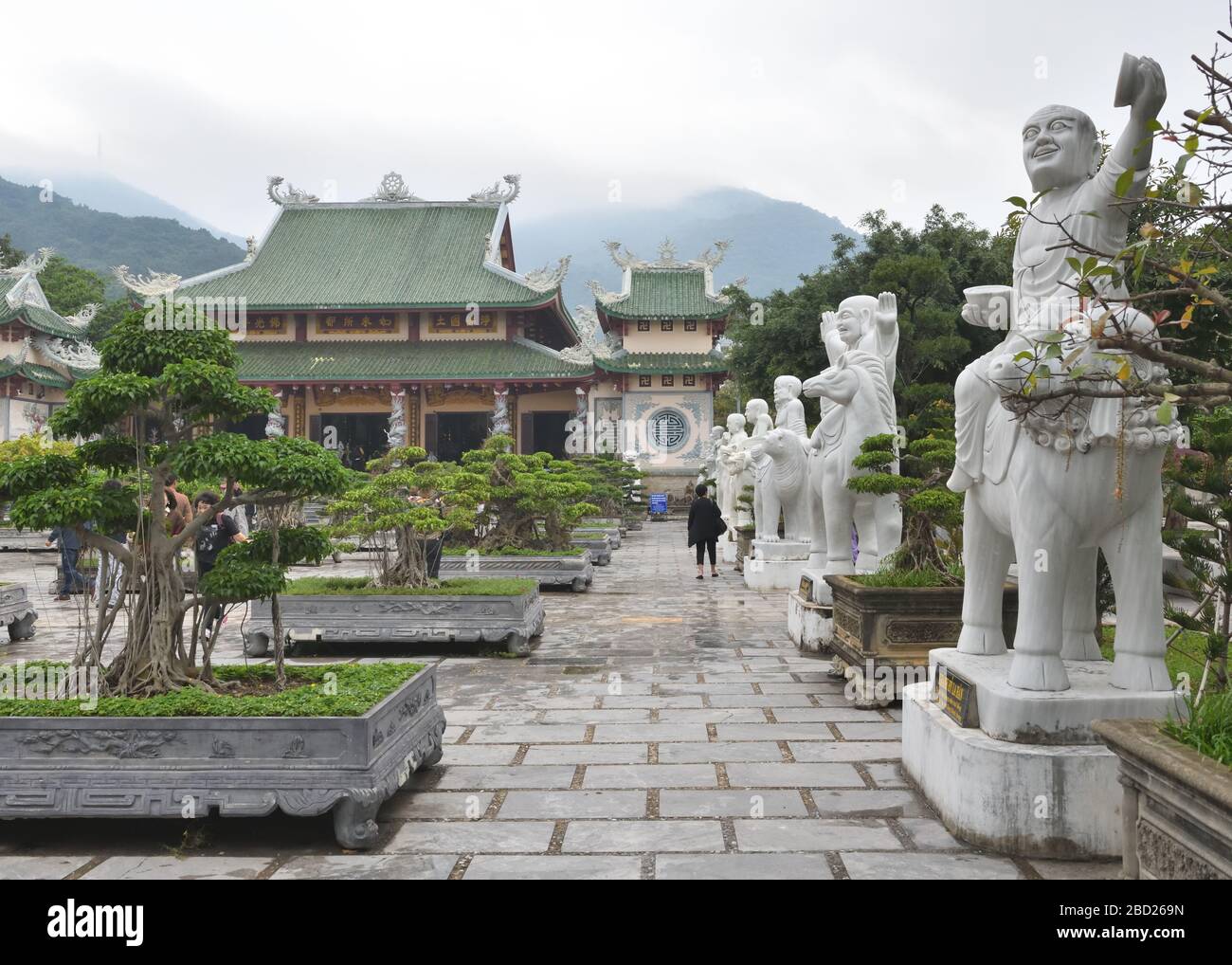 Statue di marmo fiancheggiano i giardini bonsai di Vườn Lâm Tỳ Ni al tempio buddista Chùa Linh Ứng di da Nang, Vietnam, Asia Foto Stock