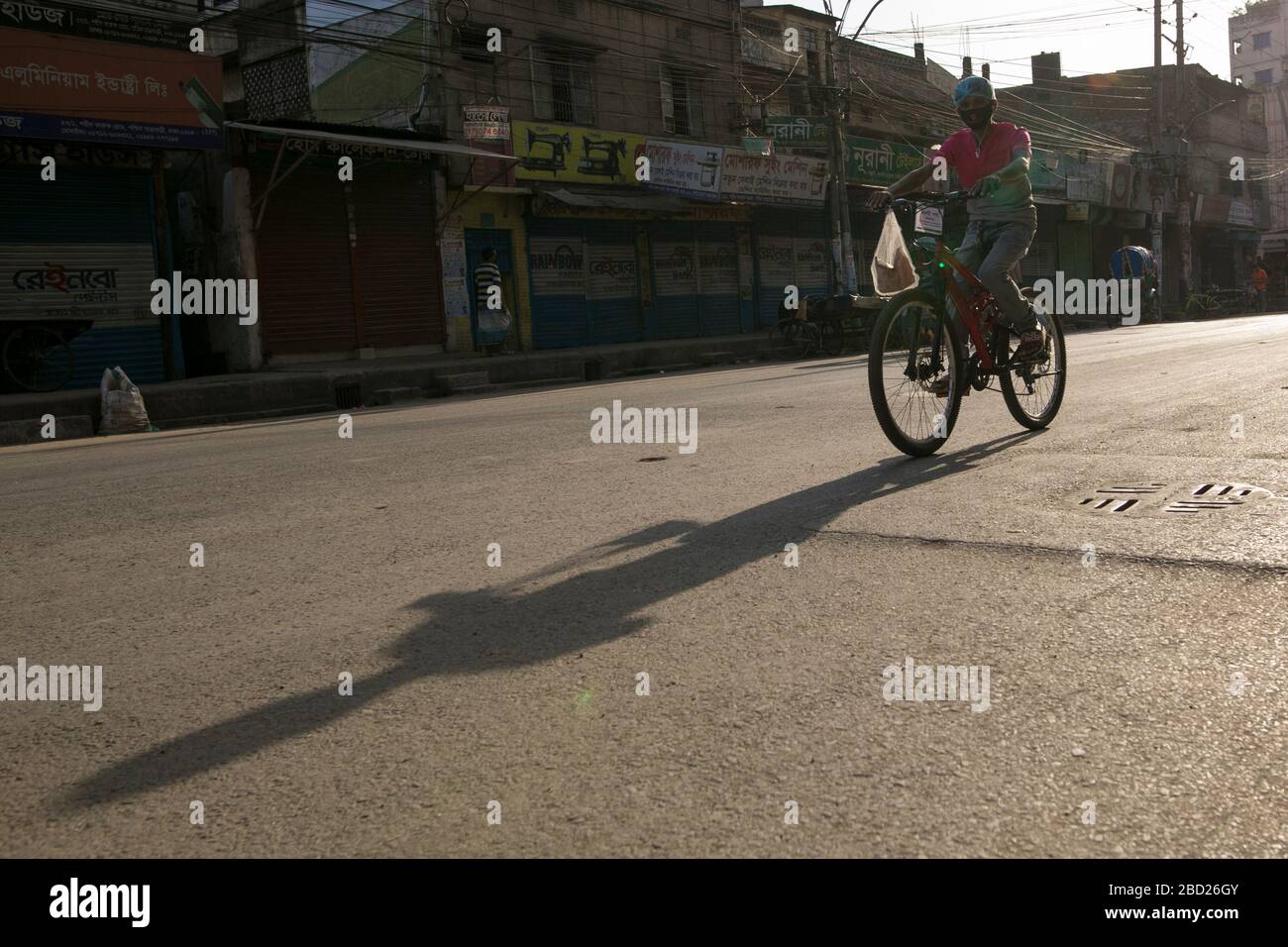 DHAKA, BANGLADESH - APRILE 06: Un ragazzo che corre in bicicletta sulla strada vuota durante il blocco imposto dal governo come misura preventiva contro il COVID-1 Foto Stock