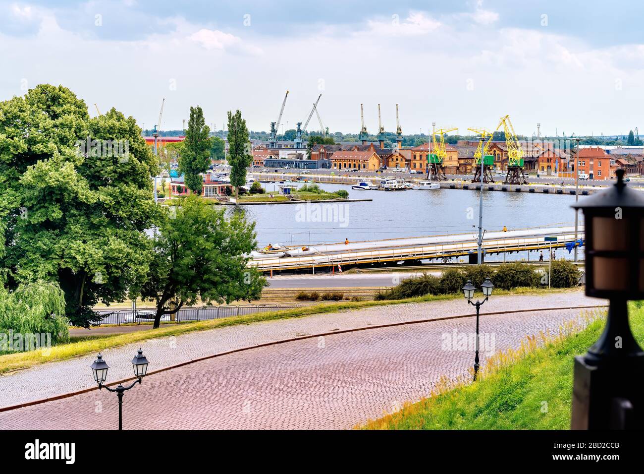 Vista da Rampart of Brave sul molo della Città Vecchia nei docklands di Szczecin con il fiume Odra, rustiche gru portuali chiamate Dzwigozaury e porto sullo sfondo Foto Stock