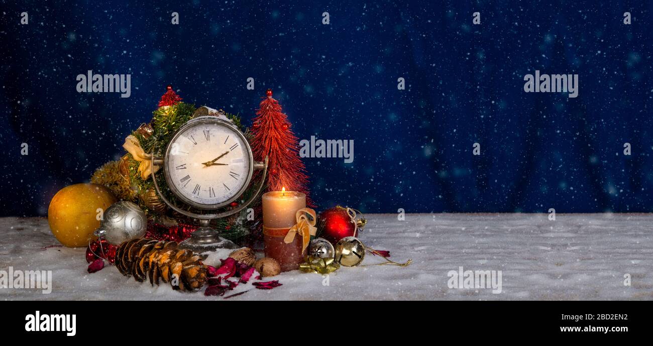 Tema natalizio con orologio e alberi sullo sfondo della neve Foto Stock