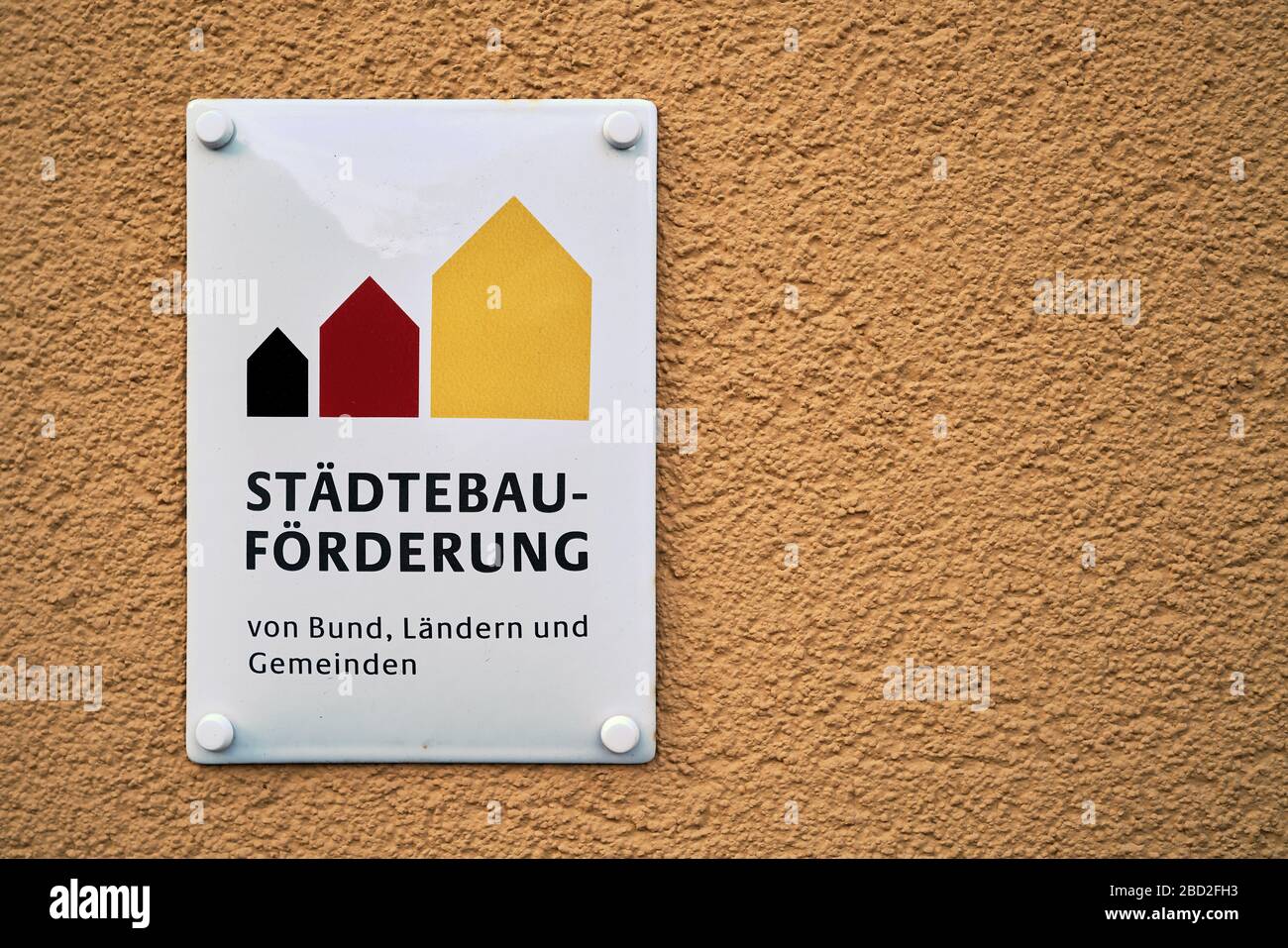 Cartello su un edificio ristrutturato con l'iscrizione sviluppo urbano. La ristrutturazione di questa casa è stata finanziata con sovvenzioni. Foto Stock