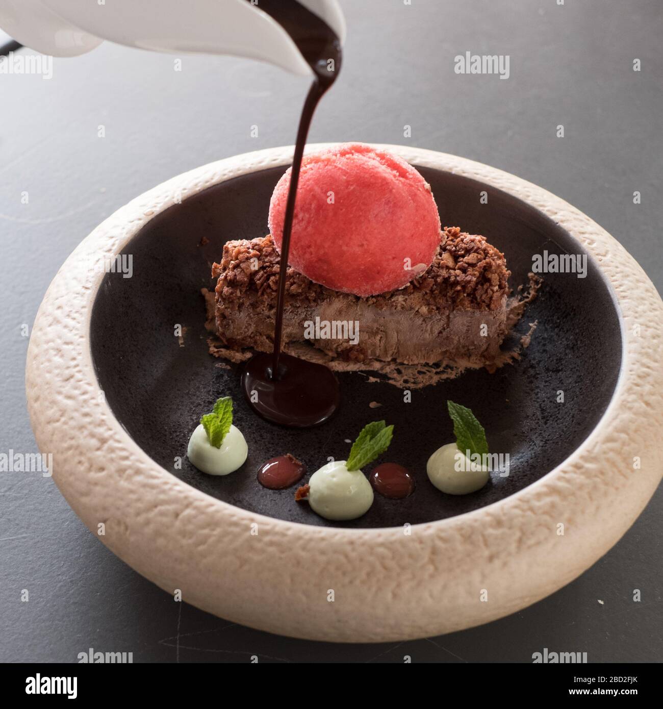 Versare il cioccolato sul dessert al ristorante Six Keys sulla penisola di Pilio, Grecia Foto Stock