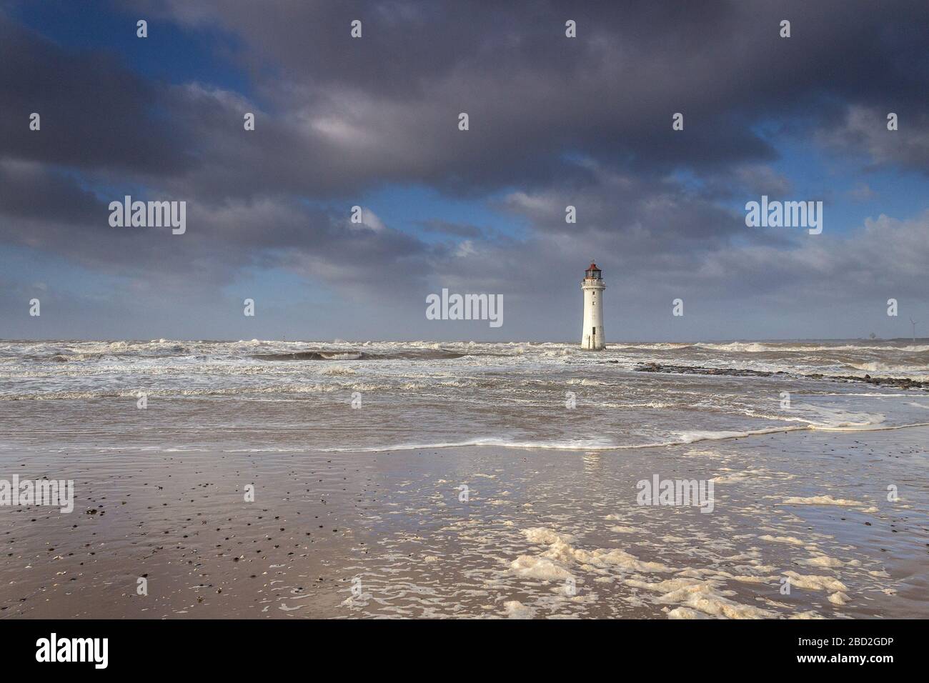 Onde di schiuma sulla spiaggia al New Brighton Lighthouse, Perch Rock, New Brighton, Wirral Foto Stock