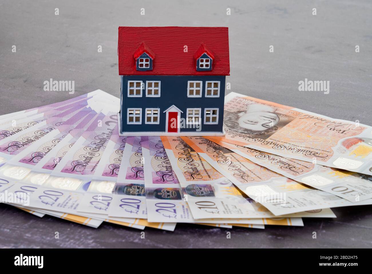Modello di casa collocato sulle banconote in valuta del Regno Unito Foto Stock