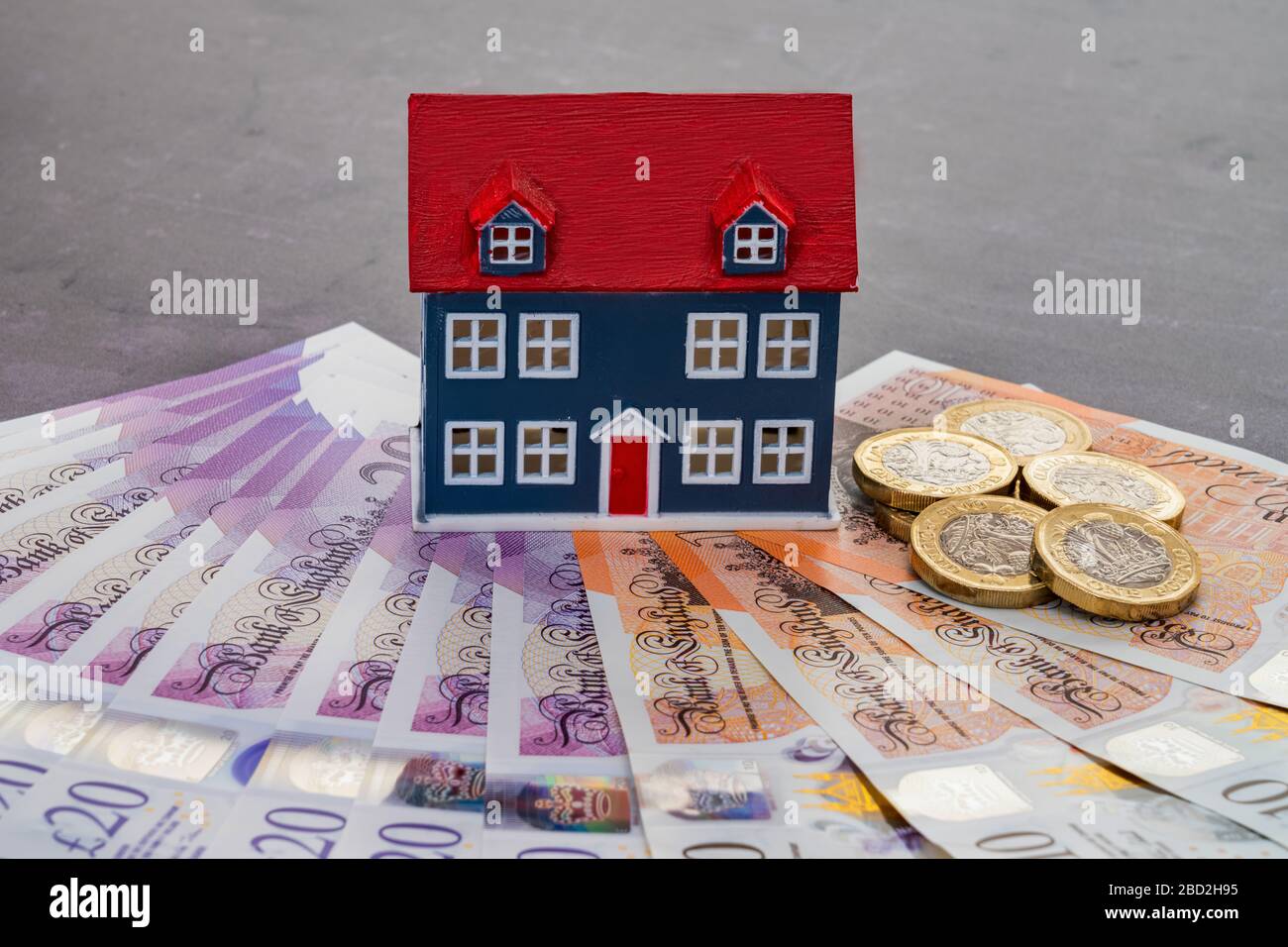 Modello di casa collocato sulle banconote in valuta del Regno Unito Foto Stock