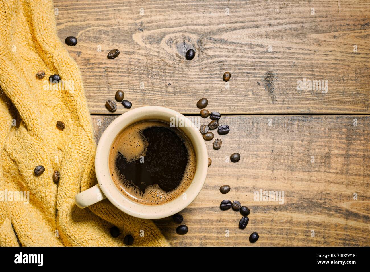 Tazza di caffè e chicchi di caffè su sfondo rustico di legno. Vista dall'alto con spazio di copia. Foto Stock