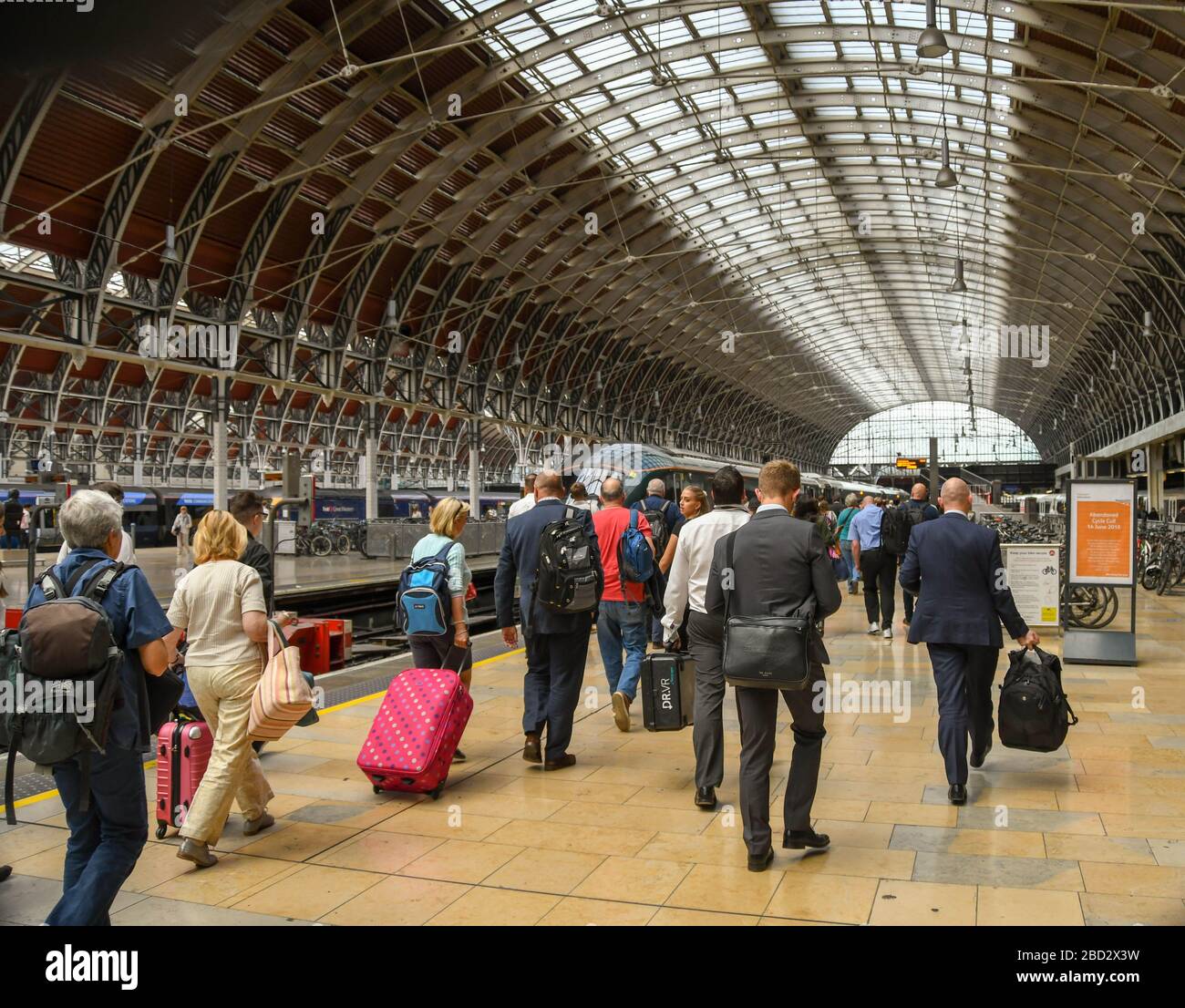 LONDRA, INGHILTERRA - LUGLIO 2018: Persone che camminano lungo una piattaforma alla Stazione di Londra Paddington per salire a bordo di un treno dopo che il numero della piattaforma è stato annunciato. Foto Stock