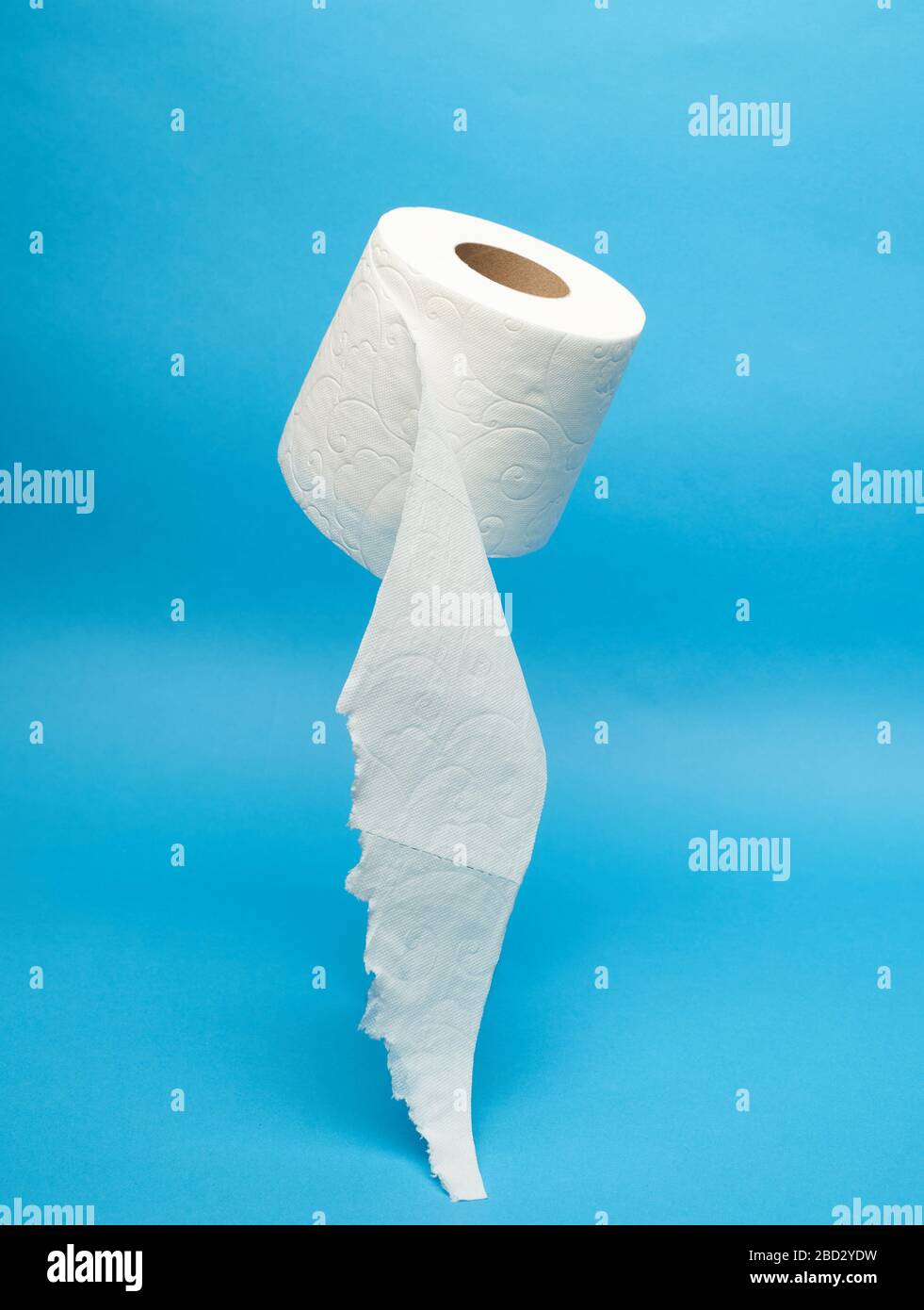 Rotolo di carta igienica bianca strappato su sfondo blu minimalista Foto Stock